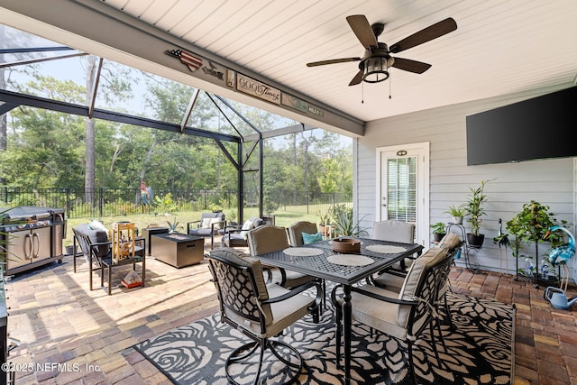 85600 Stonehurst Pkwy, Fernandina Beach, FL 32034 - view of patio featuring a fire pit, a lanai, outdoor dining area, a ceiling fan, and view of scattered trees