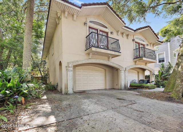 2049 Seminole Rd, Atlantic Beach, FL 32233 - view of front facade featuring a balcony, stucco siding, a tile roof, an attached garage, and concrete driveway
