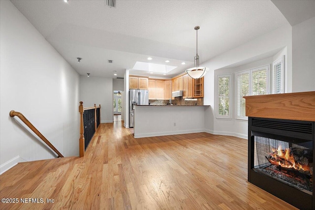2049 Seminole Rd, Atlantic Beach, FL 32233 - kitchen with stainless steel fridge, tasteful backsplash, light wood-type flooring, dark countertops, and recessed lighting