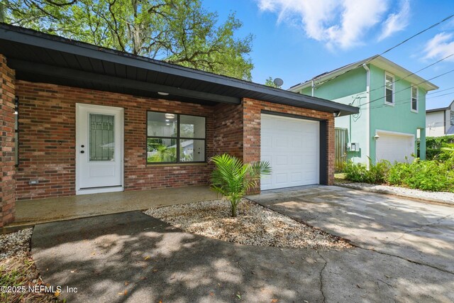 494 Acacia St, Saint Augustine Beach, FL 32080 - view of front of property with brick siding, an attached garage, and driveway
