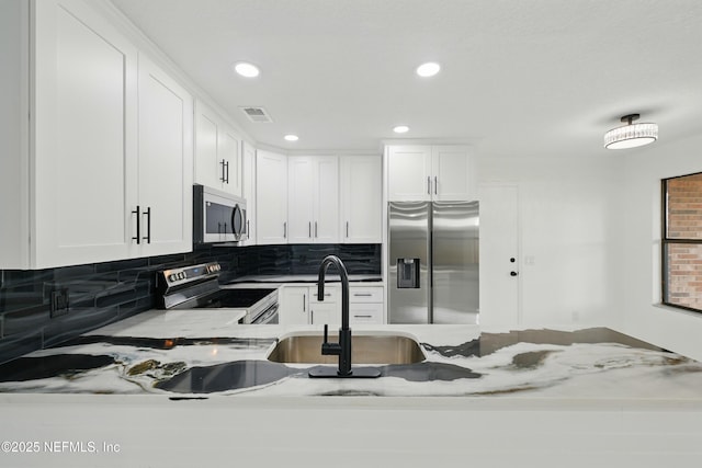 494 Acacia St, Saint Augustine Beach, FL 32080 - kitchen featuring stainless steel appliances, backsplash, white cabinets, a sink, and recessed lighting