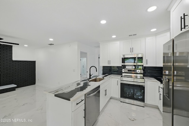 494 Acacia St, Saint Augustine Beach, FL 32080 - kitchen with appliances with stainless steel finishes, a sink, a peninsula, recessed lighting, and light marble finish floors