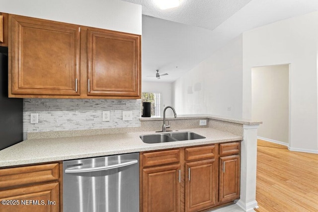 5006 Key Lime Dr Unit 306, Jacksonville, FL 32256 - kitchen featuring stainless steel dishwasher, a sink, light countertops, decorative backsplash, and light wood-type flooring