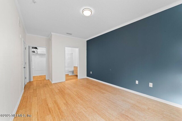 5006 Key Lime Dr Unit 306, Jacksonville, FL 32256 - unfurnished bedroom with light wood finished floors, baseboards, ensuite bathroom, ornamental molding, and a spacious closet