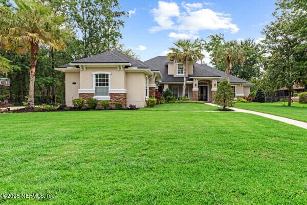 1821 Wind Ridge Ct, Fleming Island, FL 32003 - view of front of house with stucco siding and a front lawn