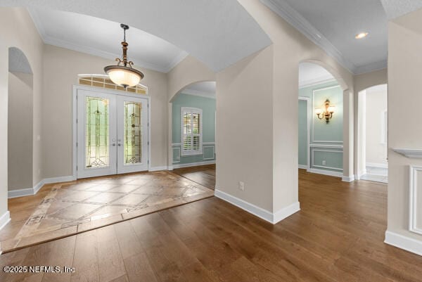1821 Wind Ridge Ct, Fleming Island, FL 32003 - entryway with ornamental molding, wood finished floors, baseboards, arched walkways, and french doors