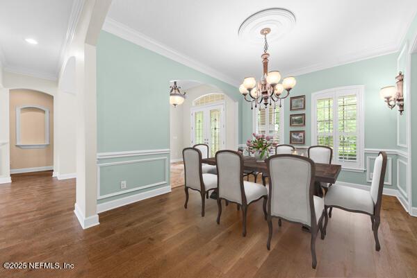 1821 Wind Ridge Ct, Fleming Island, FL 32003 - dining room featuring a chandelier, arched walkways, crown molding, and wood finished floors