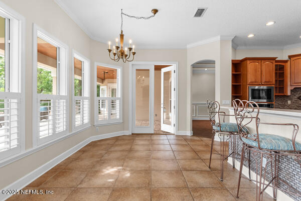 1821 Wind Ridge Ct, Fleming Island, FL 32003 - unfurnished dining area with ornamental molding, light tile patterned flooring, arched walkways, a chandelier, and recessed lighting