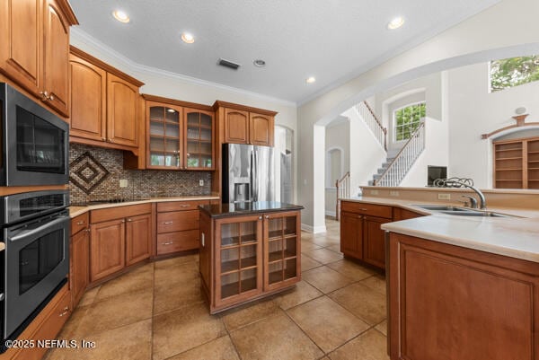 1821 Wind Ridge Ct, Fleming Island, FL 32003 - kitchen with stainless steel appliances, a sink, brown cabinets, decorative backsplash, and recessed lighting