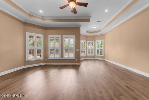 1821 Wind Ridge Ct, Fleming Island, FL 32003 - unfurnished living room with crown molding, a raised ceiling, wood finished floors, baseboards, and ceiling fan