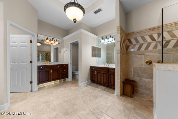 1821 Wind Ridge Ct, Fleming Island, FL 32003 - bathroom featuring vanity, toilet, and a chandelier