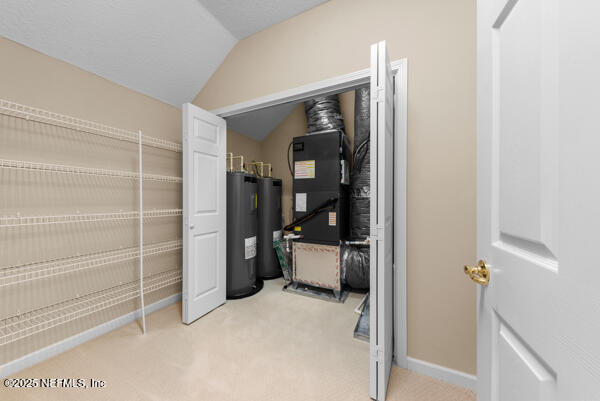 1821 Wind Ridge Ct, Fleming Island, FL 32003 - spacious closet with light carpet, lofted ceiling, water heater, and heating unit