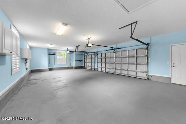 1821 Wind Ridge Ct, Fleming Island, FL 32003 - garage with a garage door opener and baseboards