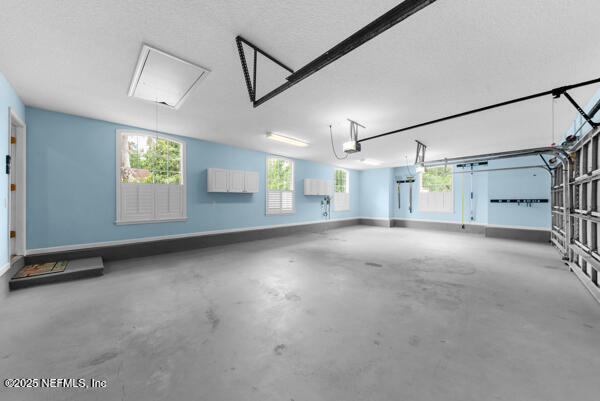 1821 Wind Ridge Ct, Fleming Island, FL 32003 - garage with a garage door opener and baseboards