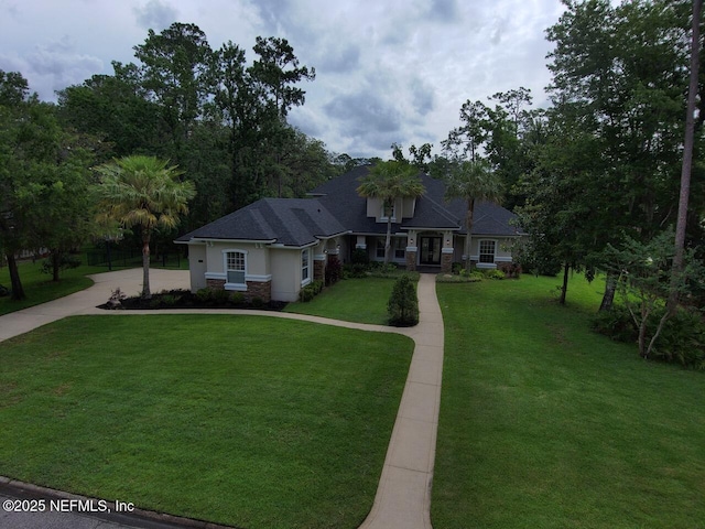 1821 Wind Ridge Ct, Fleming Island, FL 32003 - craftsman house featuring a front yard and stone siding