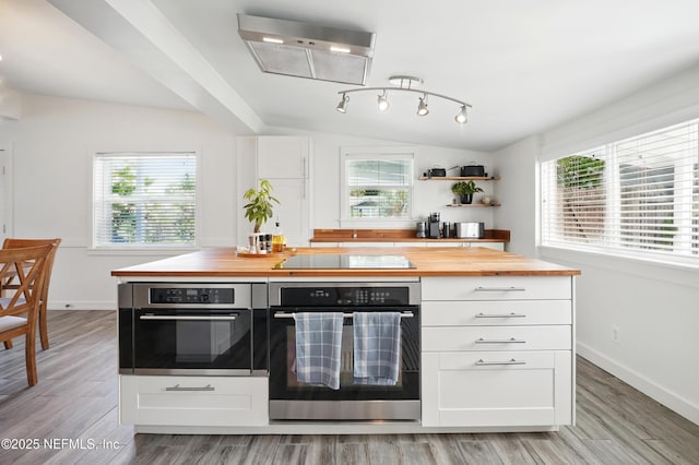 541 Margaret St, Neptune Beach, FL 32266 - kitchen featuring oven, butcher block countertops, black electric cooktop, and white cabinetry