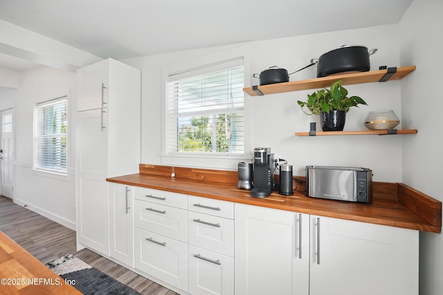 541 Margaret St, Neptune Beach, FL 32266 - kitchen with butcher block countertops, open shelves, light wood-style flooring, and white cabinetry