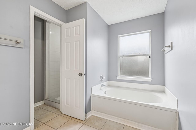 1645 Teaberry Dr, Middleburg, FL 32068 - bathroom with tile patterned flooring, a garden tub, a textured ceiling, and a stall shower
