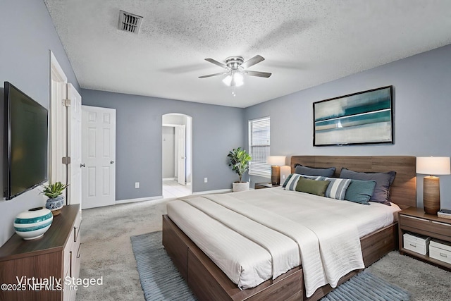 1645 Teaberry Dr, Middleburg, FL 32068 - bedroom with arched walkways, light carpet, a textured ceiling, ceiling fan, and ensuite bathroom