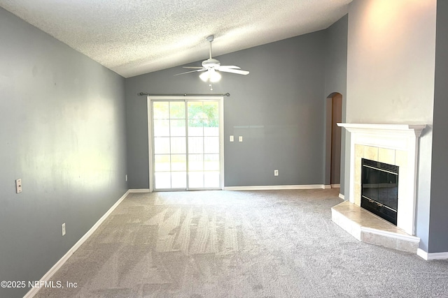 1645 Teaberry Dr, Middleburg, FL 32068 - unfurnished living room featuring lofted ceiling, a ceiling fan, carpet floors, a tile fireplace, and a textured ceiling