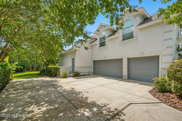 4427 Royal Tern Ct, Jacksonville Beach, FL 32250 - view of front of home with driveway, a garage, and stucco siding