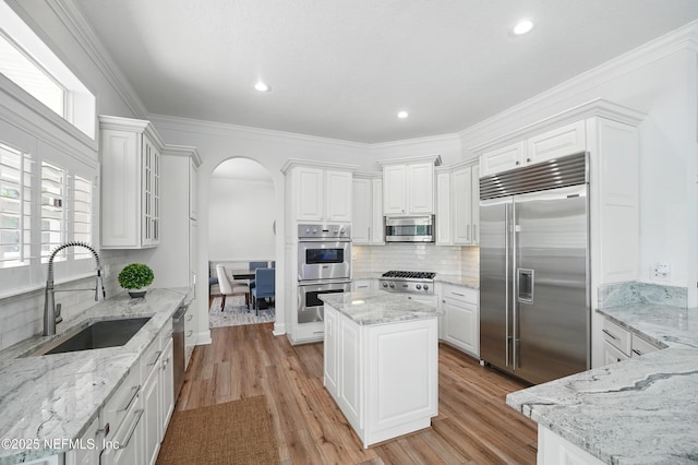 4427 Royal Tern Ct, Jacksonville Beach, FL 32250 - kitchen featuring stainless steel appliances, arched walkways, white cabinetry, tasteful backsplash, and recessed lighting