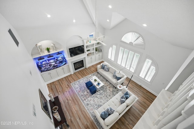 4427 Royal Tern Ct, Jacksonville Beach, FL 32250 - living room featuring a glass covered fireplace, recessed lighting, wood finished floors, a high ceiling, and a ceiling fan