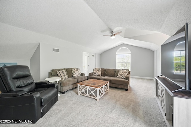 4427 Royal Tern Ct, Jacksonville Beach, FL 32250 - carpeted living room with ceiling fan, vaulted ceiling, plenty of natural light, and a textured ceiling