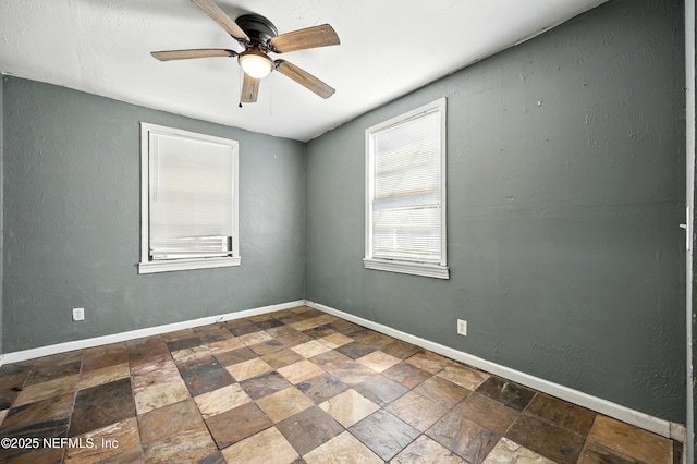 1176 Dancy St, Jacksonville, FL 32205 - empty room with dark stone finish flooring, a ceiling fan, and baseboards