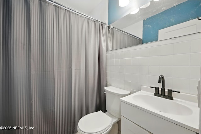 1176 Dancy St, Jacksonville, FL 32205 - full bath with tile walls, toilet, vanity, backsplash, and a shower with shower curtain