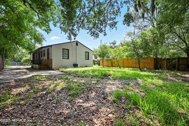 1176 Dancy St, Jacksonville, FL 32205 - back of property with a fenced backyard, stucco siding, and a patio