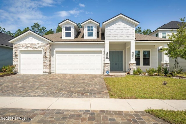 286 Holly Landing Way, Saint Augustine, FL 32092 - view of front facade with decorative driveway, an attached garage, a front yard, and stone siding