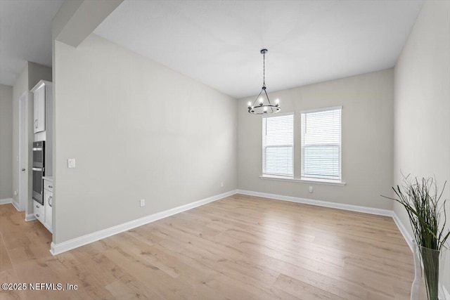 286 Holly Landing Way, Saint Augustine, FL 32092 - unfurnished room with a chandelier, baseboards, and light wood-style flooring
