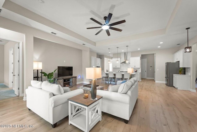 286 Holly Landing Way, Saint Augustine, FL 32092 - living area featuring a ceiling fan, baseboards, a tray ceiling, light wood-style floors, and recessed lighting
