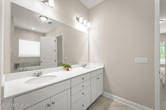 286 Holly Landing Way, Saint Augustine, FL 32092 - bathroom with double vanity, a garden tub, baseboards, and tile patterned floors