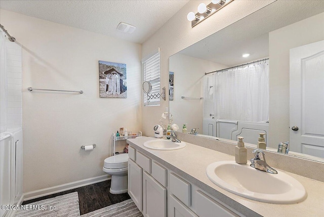 3448 Cliffside Way, Green Cove Springs, FL 32043 - full bath featuring wood finished floors, toilet, double vanity, curtained shower, and a textured ceiling