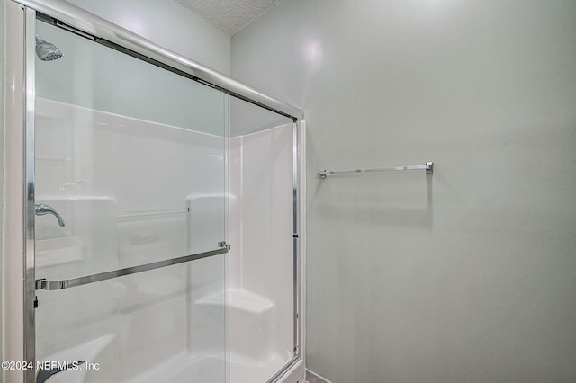 112 Laurel Wood Way Unit 202, Saint Augustine, FL 32086 - full bathroom featuring a shower with shower door and a textured ceiling