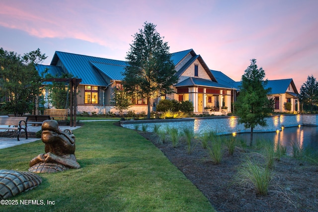 28 Hogan Ct, Saint Augustine, FL 32092 - back of property at dusk with a standing seam roof, metal roof, and a lawn