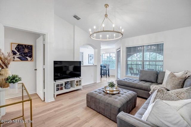 10961 Burnt Mill Rd Unit 1534, Jacksonville, FL 32256 - living area with arched walkways, a chandelier, light wood finished floors, baseboards, and lofted ceiling