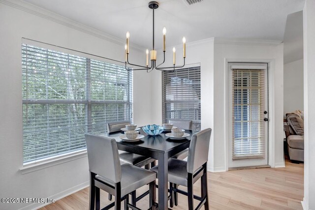 10961 Burnt Mill Rd Unit 1534, Jacksonville, FL 32256 - dining space featuring a chandelier, light wood-style floors, plenty of natural light, baseboards, and crown molding