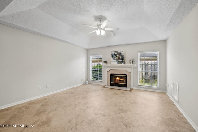 4458 Deep River Way E, Jacksonville, FL 32224 - unfurnished living room with a tray ceiling, plenty of natural light, a fireplace, a textured ceiling, and ceiling fan