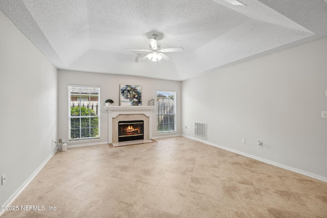 4458 Deep River Way E, Jacksonville, FL 32224 - unfurnished living room with a tray ceiling, healthy amount of natural light, ceiling fan, a high end fireplace, and a textured ceiling