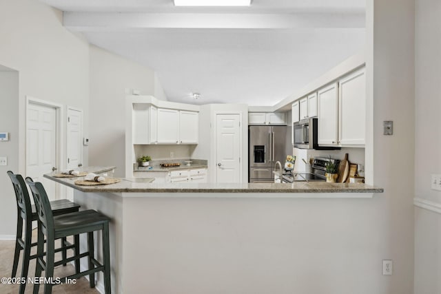 4458 Deep River Way E, Jacksonville, FL 32224 - kitchen with stainless steel appliances, a kitchen bar, light stone counters, and white cabinets