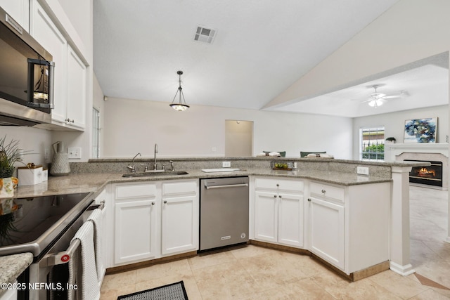 4458 Deep River Way E, Jacksonville, FL 32224 - kitchen with stainless steel appliances, vaulted ceiling, light stone counters, white cabinets, and ceiling fan