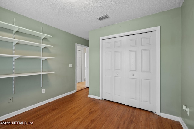 4458 Deep River Way E, Jacksonville, FL 32224 - unfurnished bedroom featuring wood finished floors, a closet, and a textured ceiling