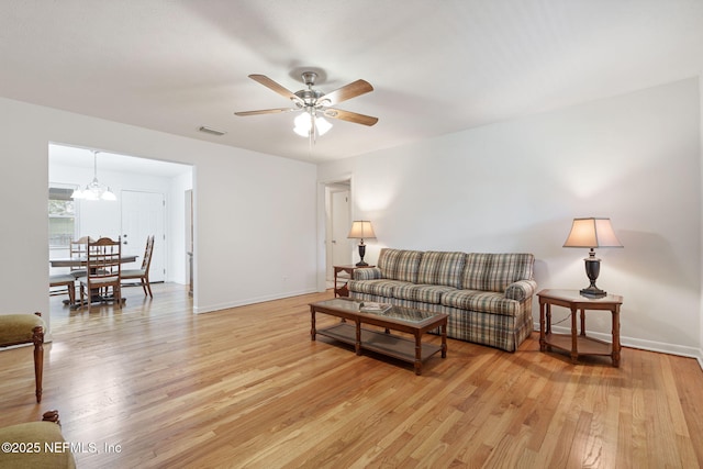 3130 Honeywood Dr, Jacksonville, FL 32277 - living area with a ceiling fan, light wood-style flooring, a chandelier, and baseboards