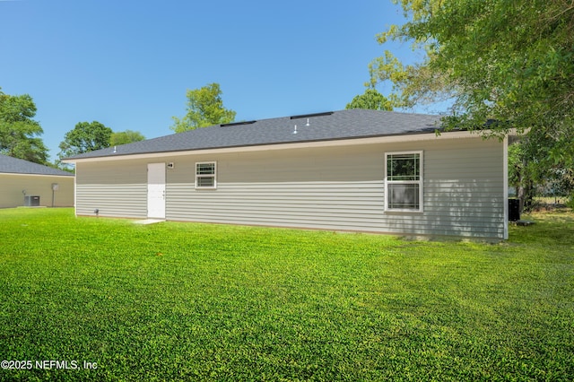 7127 Stetson St, Keystone Heights, FL 32656 - back of house featuring a lawn, a shingled roof, and central air condition unit