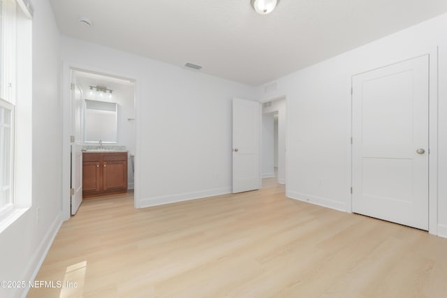 7127 Stetson St, Keystone Heights, FL 32656 - unfurnished bedroom with a sink, light wood-style flooring, and baseboards