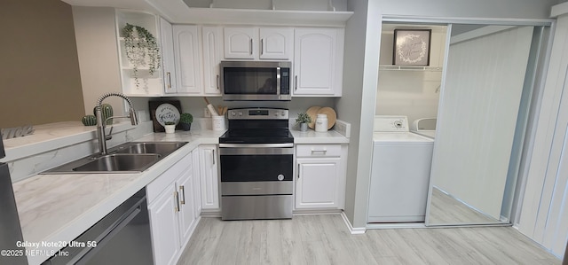 7640 Las Palmas Way Unit 149, Jacksonville, FL 32256 - kitchen featuring stainless steel appliances, washer / clothes dryer, a sink, white cabinetry, and light countertops