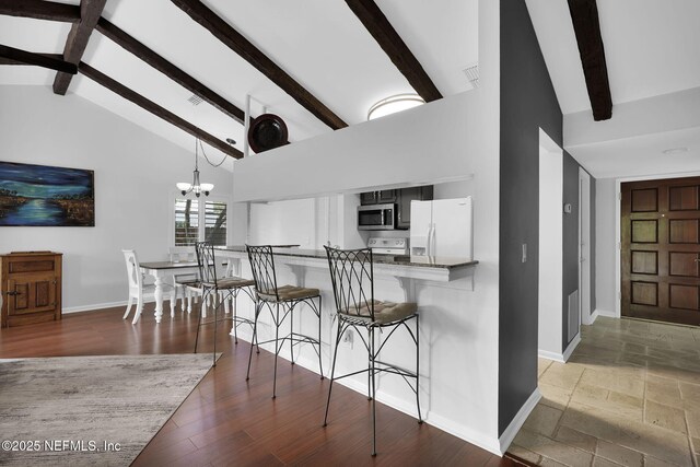 721 Sandy Oaks Ct, Ponte Vedra Beach, FL 32082 - kitchen featuring white appliances, baseboards, beam ceiling, high vaulted ceiling, and a kitchen breakfast bar